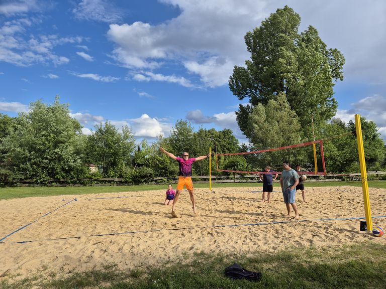 Beachvolleyball als etabliertes After-Work-Event in Dresden Beachvolleyball-Feld und Kollege im MMS-Trikot