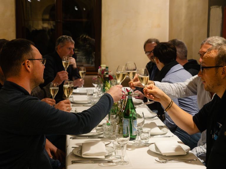 Kolleg*innen stoßen mit Sekt an
