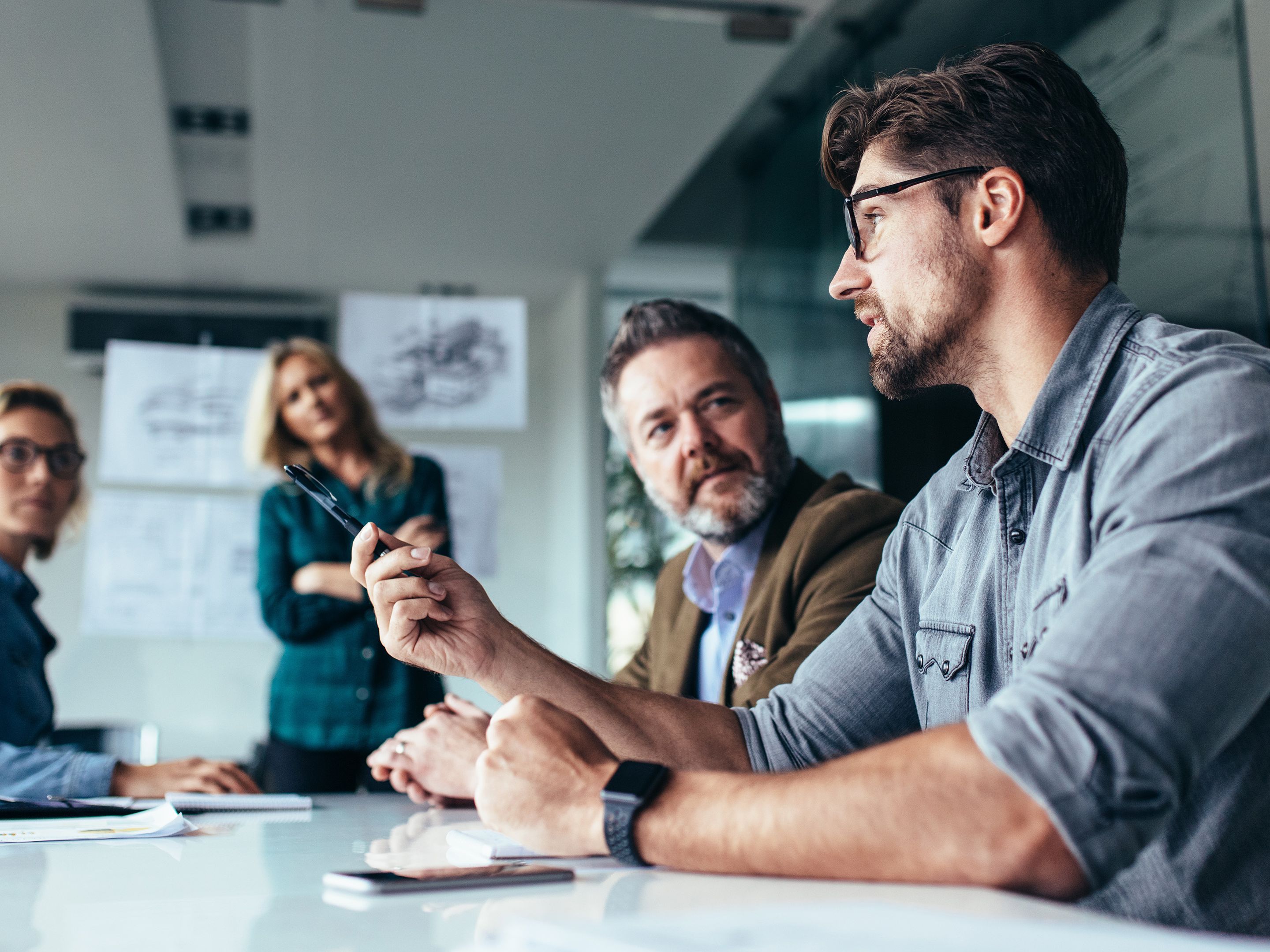 illustrative Grafik: 4 Menschen in einem Meeting am Brainstorming