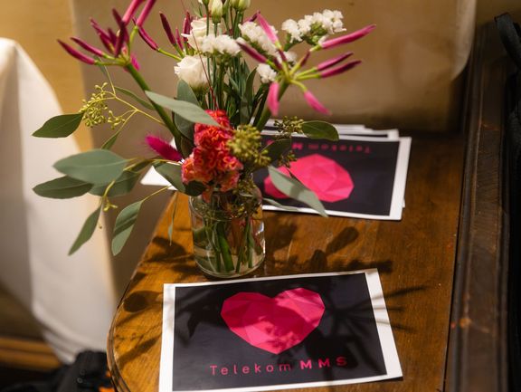 Tisch-Deko mit magenta-farbenen Blumen und Tischkarten