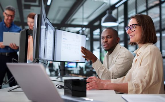 Illustrative Grafik: Zwei Data Analysten vor Bildschirmen