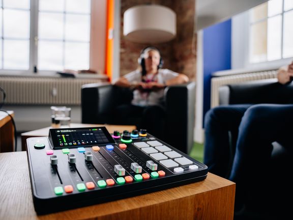 Podcast Aufnahmegerät und Hanna im Hintergrund