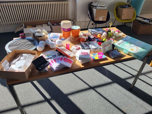 Bild eines Tisches mit verschiedenen Artikeln, die im Rahmen der Aufräumaktion gesammelt wurden: Blumentöpfe, Schreibmaterial, Shirts und vieles mehr