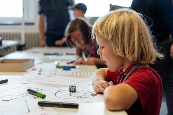 Ein Kind malt einen Parcour für einen Roboter